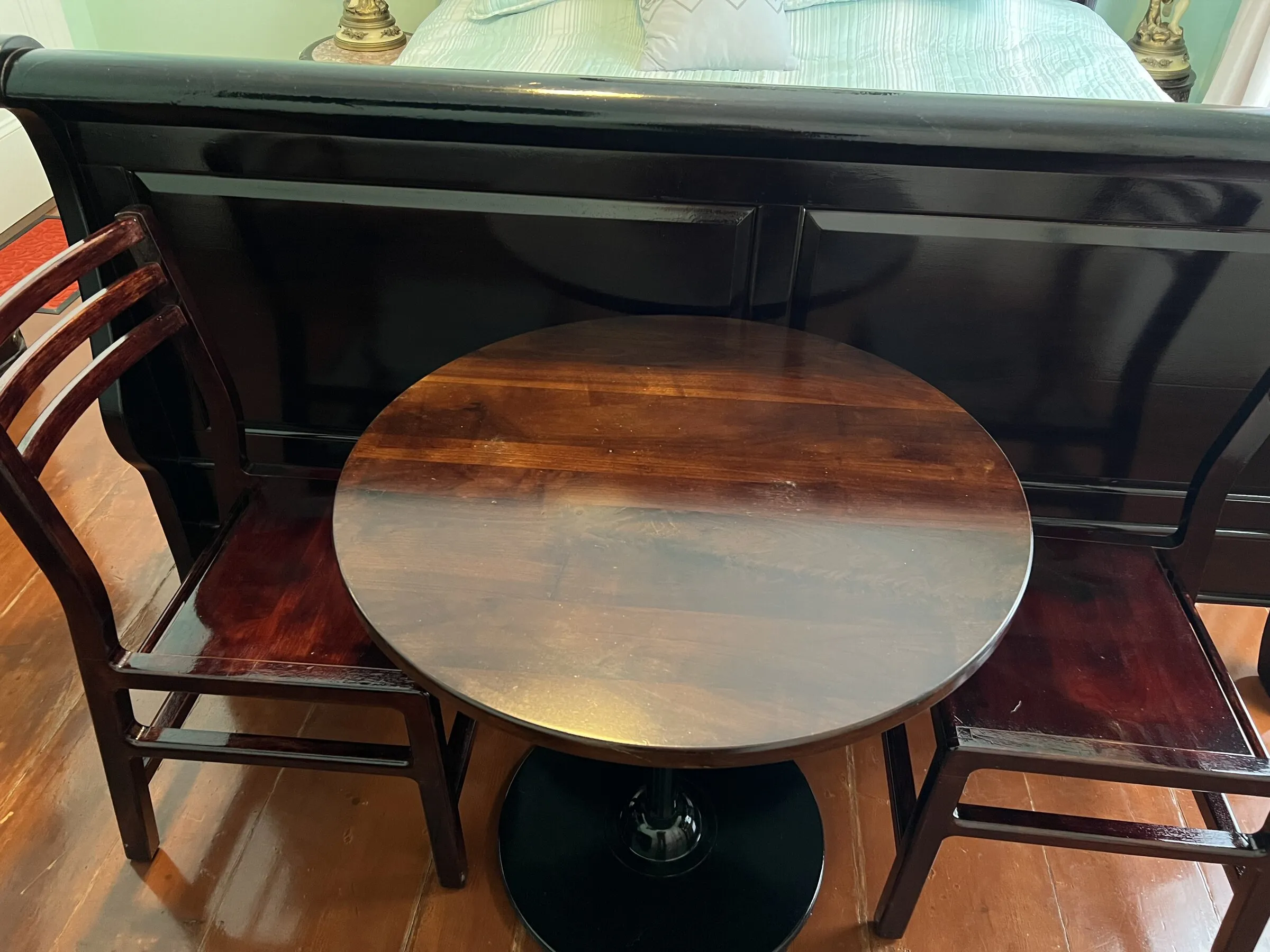 A table and two chairs at the foot of the bed