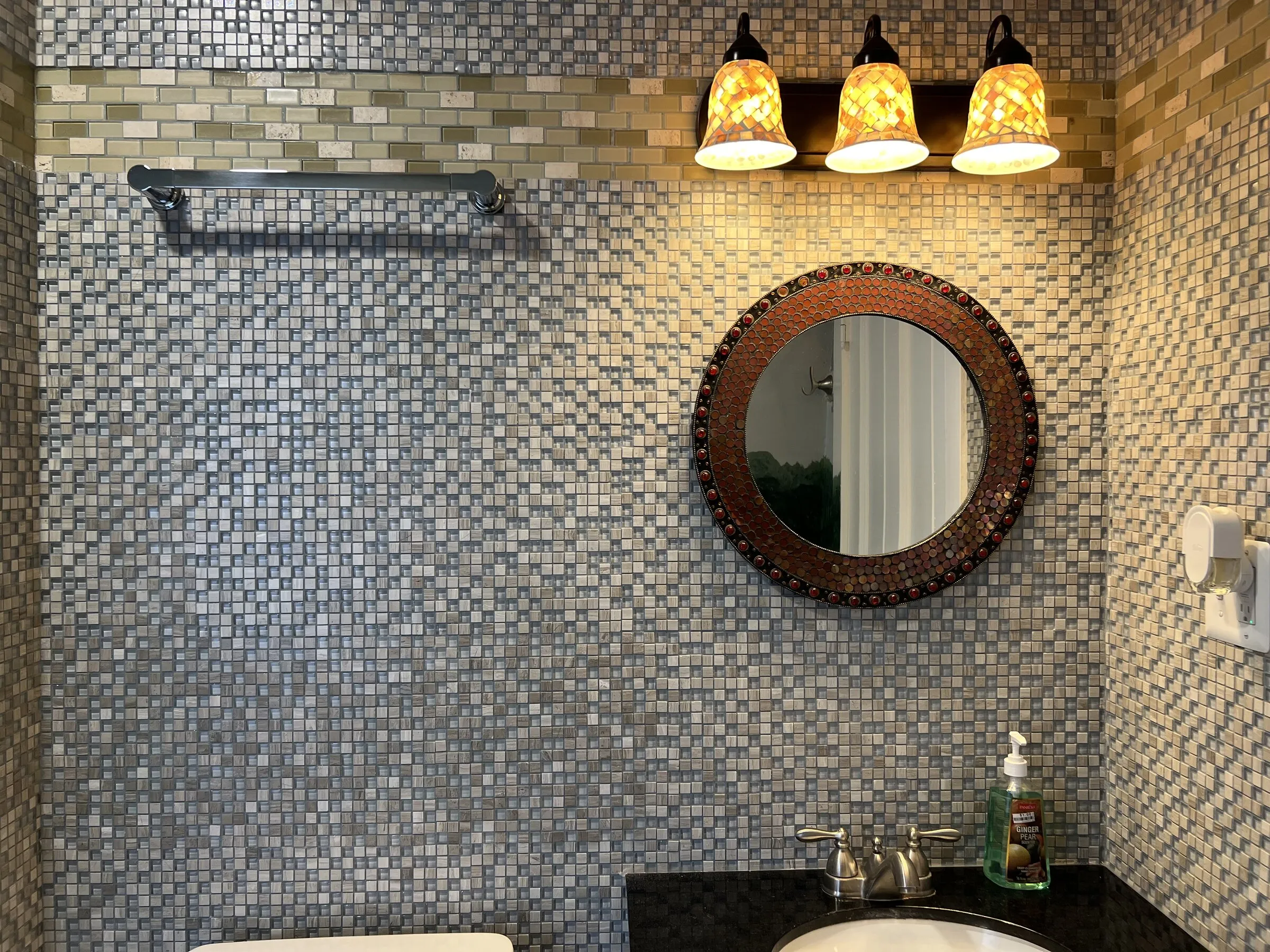 The vanity mirror and glass-tiled walls